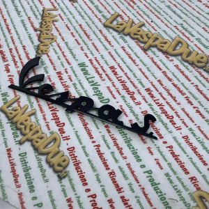 Targhetta scritta anteriore blu notte per VESPA S. SPRINT VLB1T 52001> VLB2T 50001> in alluminio anodizzato con 3 pioli di fissaggio interasse 53 81 mm prodotto italiano scritta 