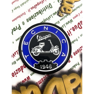 Écusson en résine de 53 mm de diamètre sur base en aluminium. Logo vintage VESPA TECNICA 1946 en aluminium bleu et noir, à appliquer sur les accessoires VESPA à l'aide d'un adhésif. Ø 53 mm