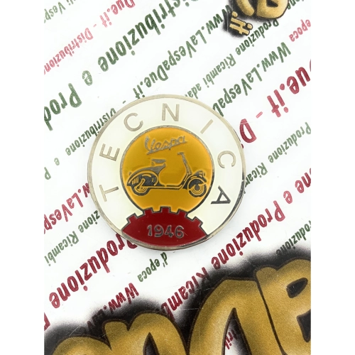Écusson logo vintage VESPA TECNICA 1946 en aluminium jaune et ivoire, Ø 41 mm, à appliquer sur les accessoires VESPA grâce à un adhésif.